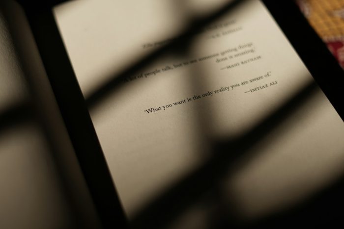 An open book with printed lines in bands of warm sunlight and shadow