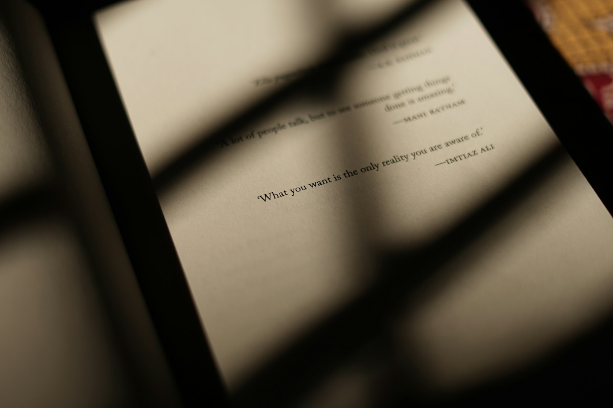 An open book with printed lines in bands of warm sunlight and shadow