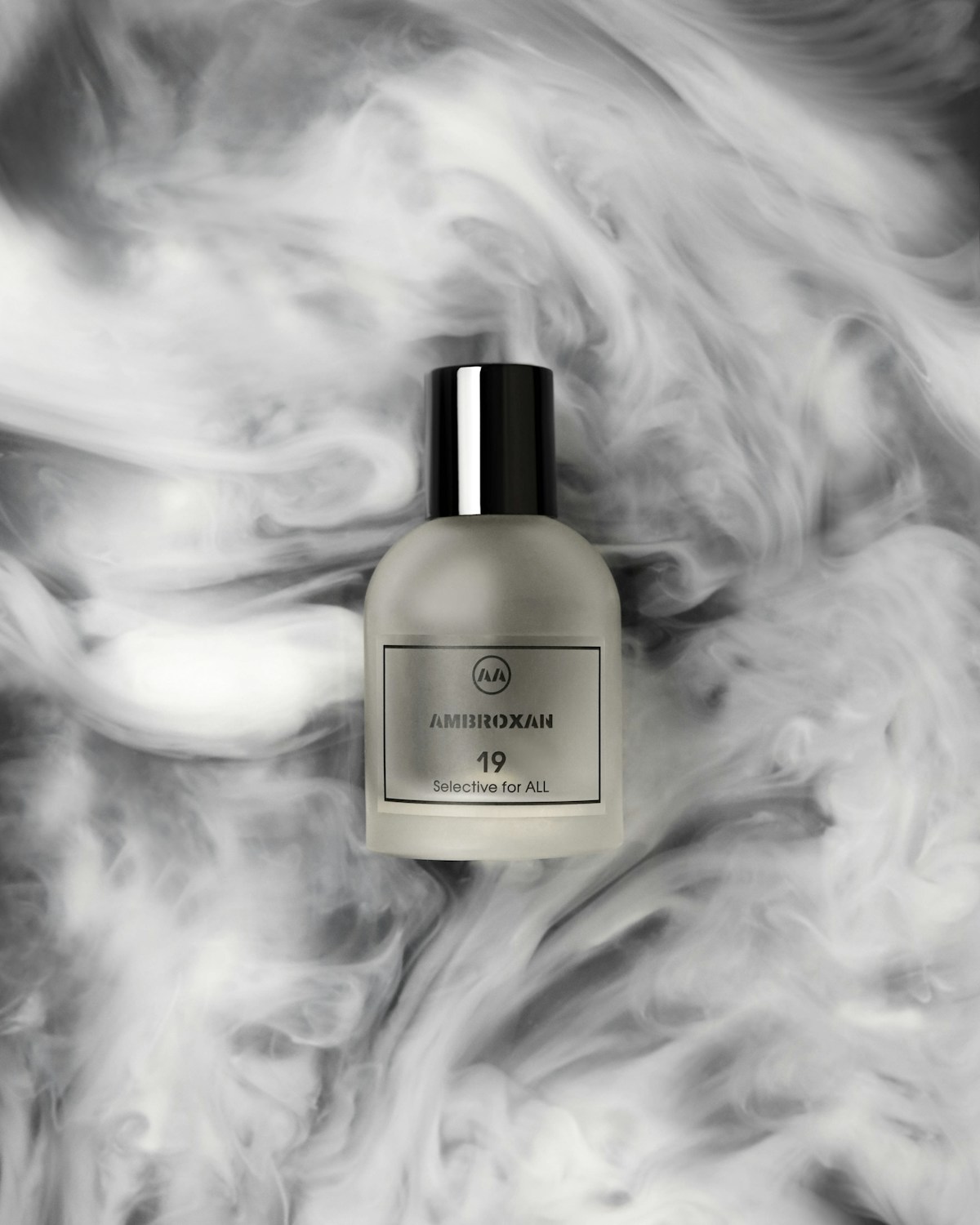 Frosted perfume bottle with a black cap surrounded by white smoke