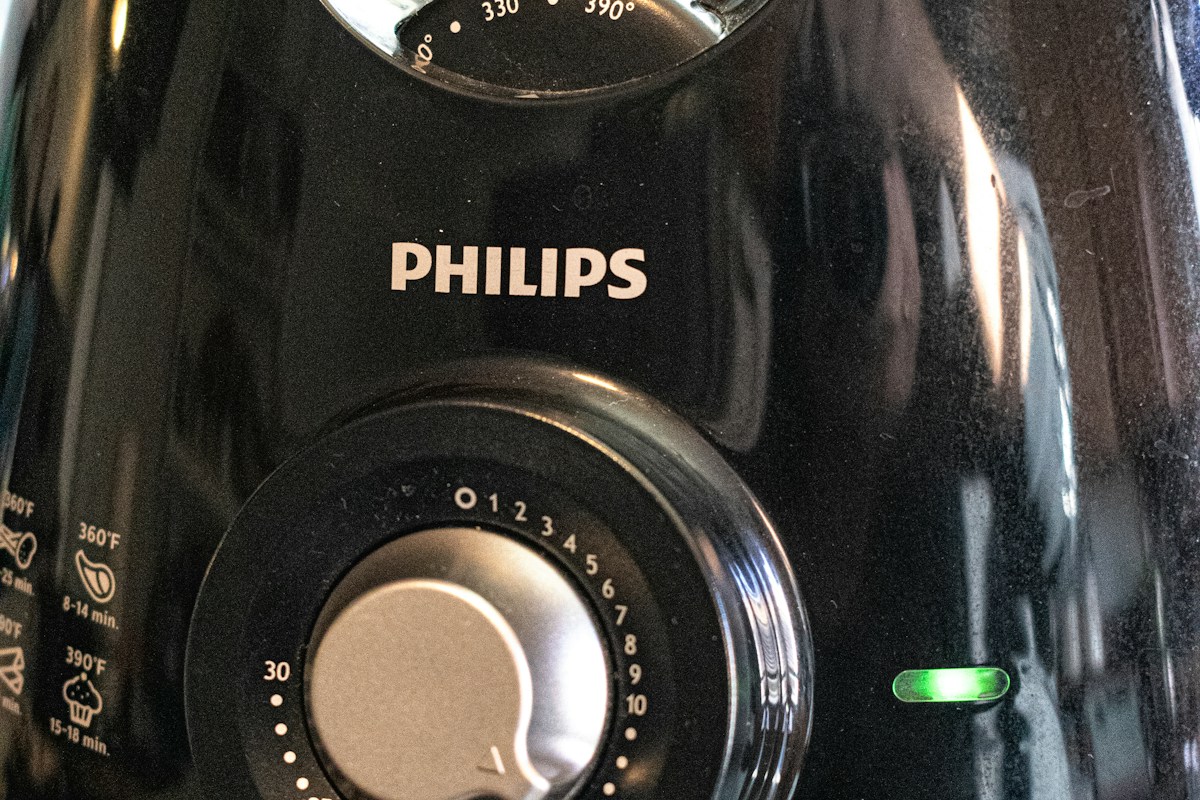 Close-up of temperature and timer controls on a black Philips air fryer