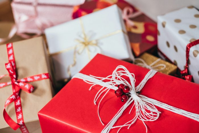 Wrapped gifts in red, white and brown paper tied with ribbon and string